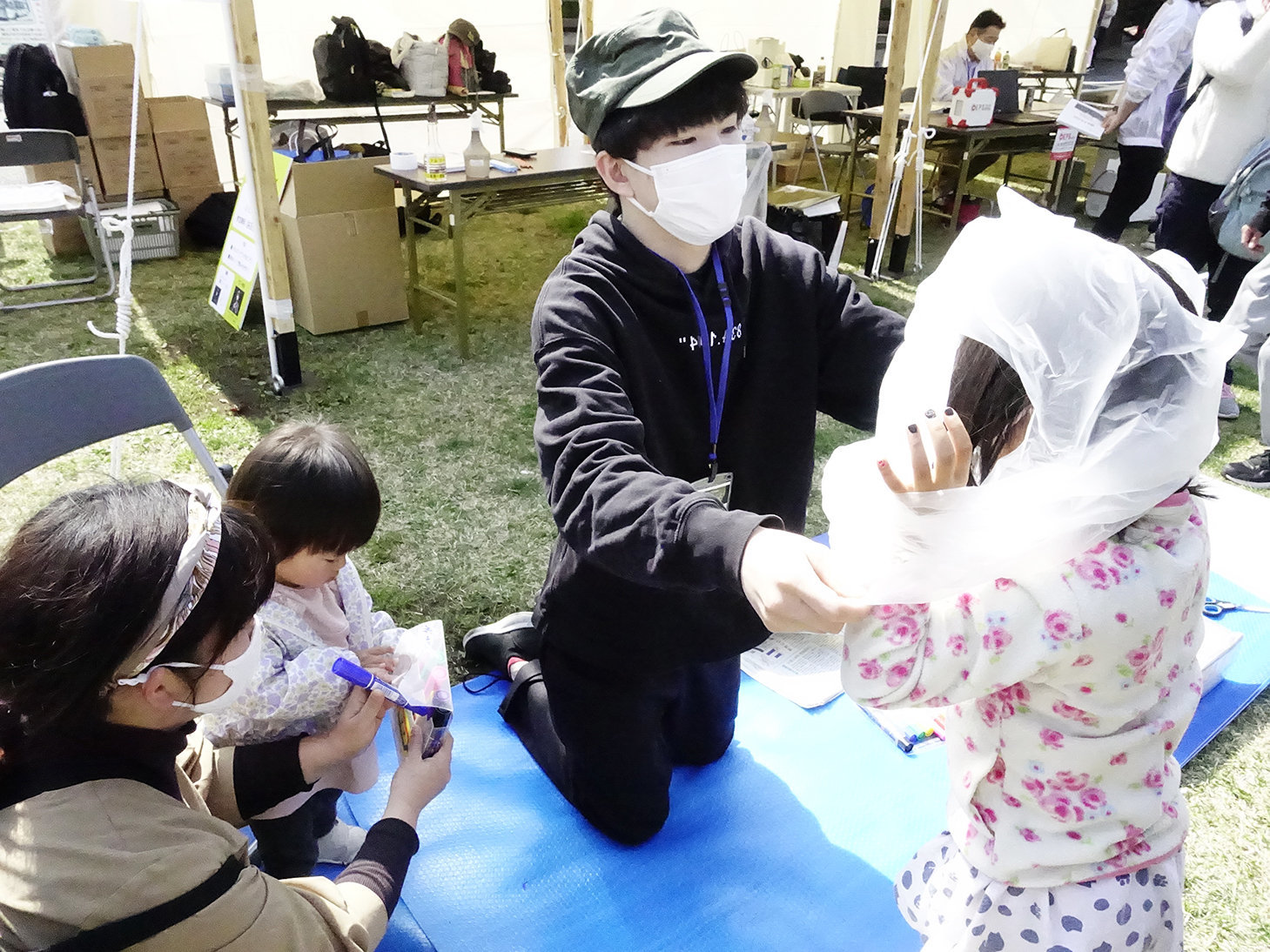 ゴミ袋を活用した防寒具の作り方を紹介する静岡大学学生防災ネットワークのメンバー（右から2人目）